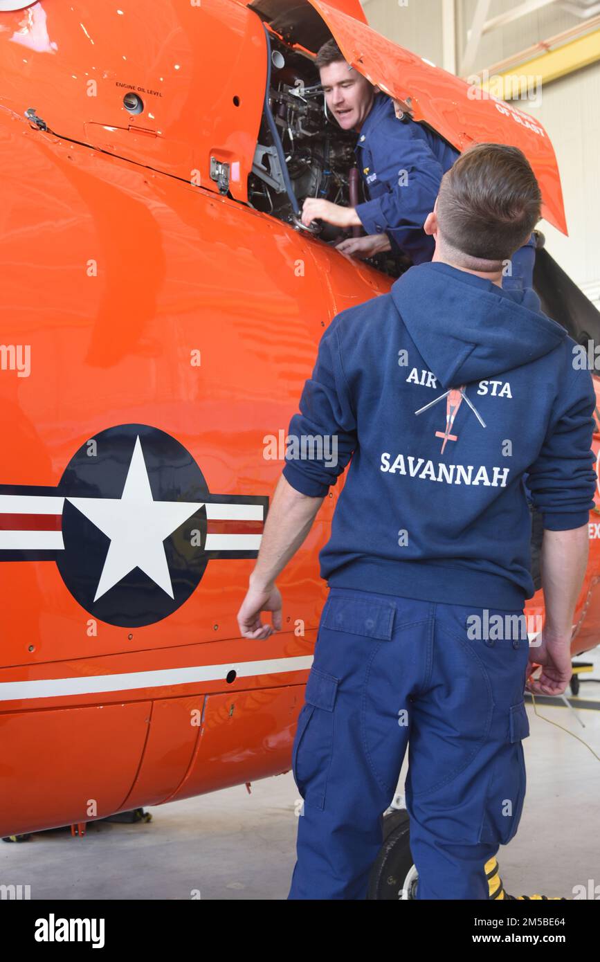 U.S. Coast Guard Petty Officer 3rd Class Bryce Kitchen (top), an aviation maintenance technician, and Airman Michael Rustine, both assigned to the aviation engineering department at Coast Guard Air Station Savannah, Georgia, conduct an inspection on an MH-65 dolphin helicopter, Feb. 21, 2022. Air Station Savannah's area of responsibility cover approximately 450 miles of shoreline from the northern border of South Carolina to Melbourne, Florida. Stock Photo
