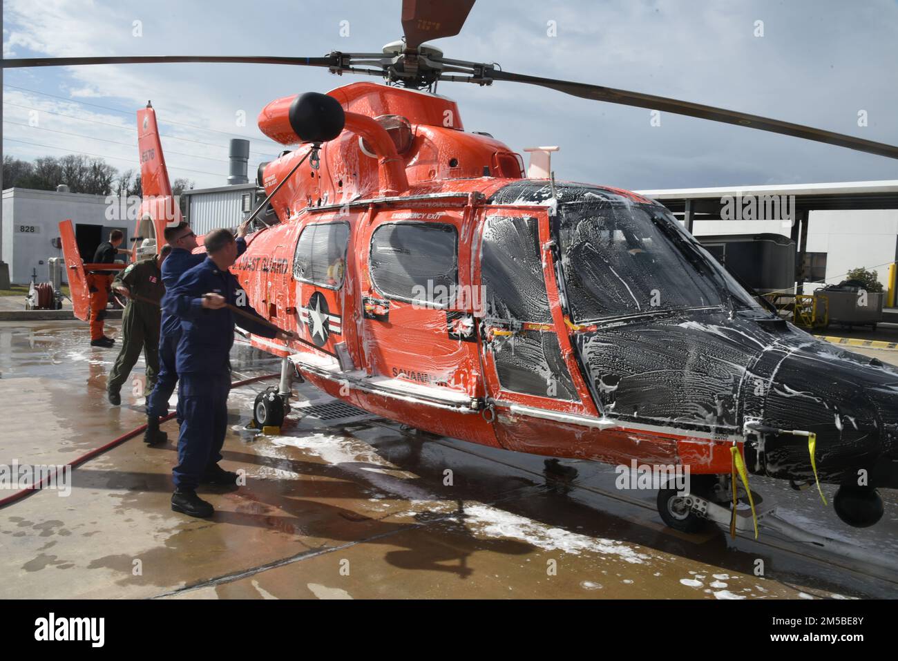 U.S. Coast Guardsmen assigned to Coast Guard Air Station Savannah, Georgia, provide a fresh water wash to an MH-65 dolphin helicopter, Feb. 21, 2022. Air Station Savannah's area of responsibility cover approximately 450 miles of shoreline from the northern border of South Carolina to Melbourne, Florida. Stock Photo