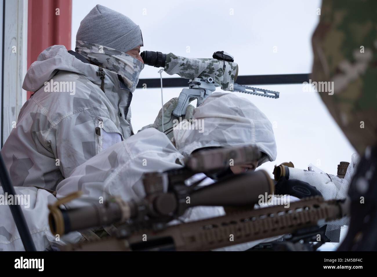 A U.S. paratrooper scans for targets behind a Barrett .50-caliber sniper  rifle while on a