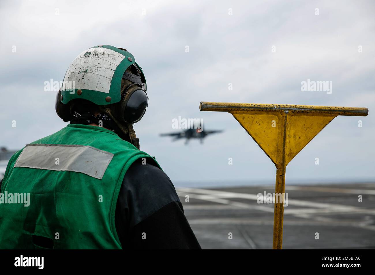 PHILIPPINE SEA (Feb. 22, 2022) Aviation Boatswain's Mate (Equipment) Airman Riley Odum, from Litchfield, N.H., observes flight operations on the flight deck of the Nimitz-class aircraft carrier USS Abraham Lincoln (CVN 72). Abraham Lincoln Strike Group is on a scheduled deployment in the U.S. 7th Fleet area of operations to enhance interoperability through alliances and partnerships while serving as a ready-response force in support of a free and open Indo-Pacific region. Stock Photo