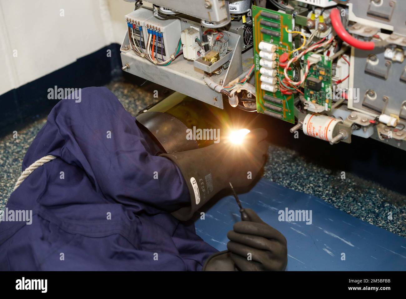 PHILIPPINE SEA (Feb. 22, 2022) Electrician’s Mate 3rd Class Ian Lemyre, from Kalama, Wash., adjusts a potentiometer aboard the Nimitz-class aircraft carrier USS Abraham Lincoln (CVN 72). Abraham Lincoln Strike Group is on a scheduled deployment in the U.S. 7th Fleet area of operations to enhance interoperability through alliances and partnerships while serving as a ready-response force in support of a free and open Indo-Pacific region. Stock Photo
