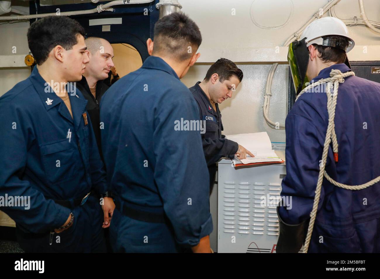 PHILIPPINE SEA (Feb. 22, 2022) Sailors review the aircraft electrical service station (AESS) technical manual prior to conducting maintenance aboard the Nimitz-class aircraft carrier USS Abraham Lincoln (CVN 72). Abraham Lincoln Strike Group is on a scheduled deployment in the U.S. 7th Fleet area of operations to enhance interoperability through alliances and partnerships while serving as a ready-response force in support of a free and open Indo-Pacific region. Stock Photo