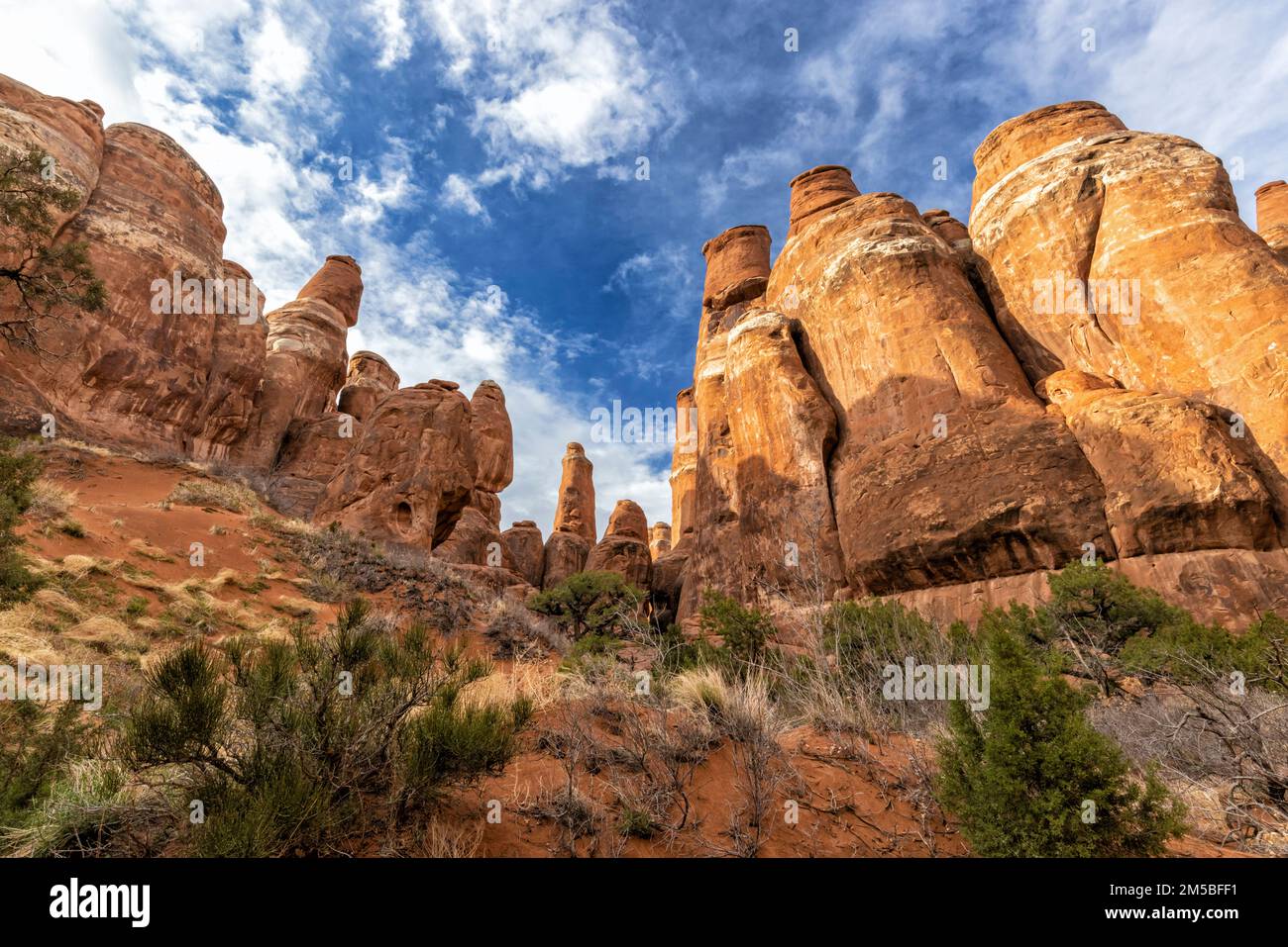 Two rows of fins cross above sandy dunes in the Fiery Furnace in Arches National Park near Moab, Utah. Stock Photo