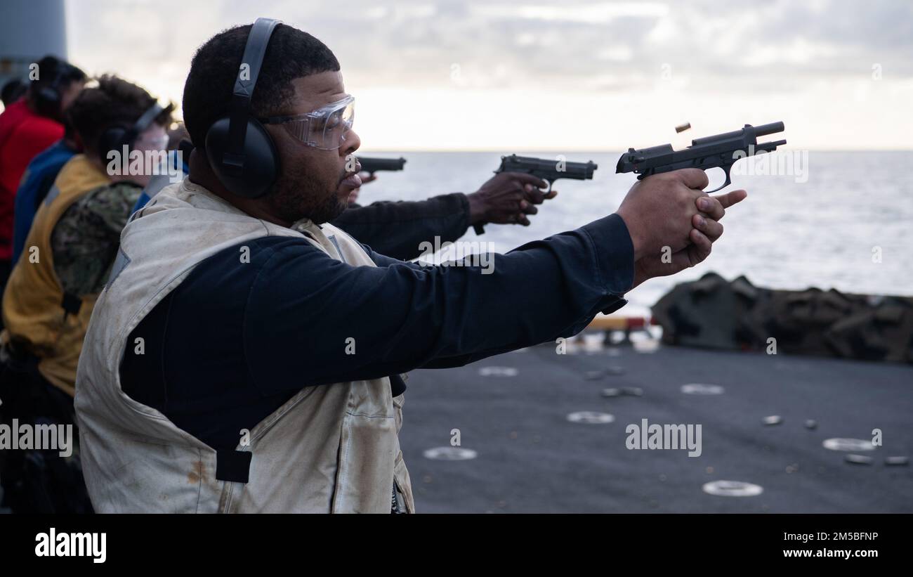 PACIFIC OCEAN (Feb. 22, 2022) Operations Specialist 1st Class Charles Powell, a native of Fort Worth, Texas, assigned to Wasp-class amphibious assault ship USS Essex (LHD 2), fires an M9 service pistol aboard Essex during a small arms gun shoot, Feb. 22, 2022. Sailors and Marines of Essex Amphibious Ready Group (ARG) and the 11th Marine Expeditionary Unit (MEU) are underway conducting routine operations in U.S. 3rd Fleet. Stock Photo