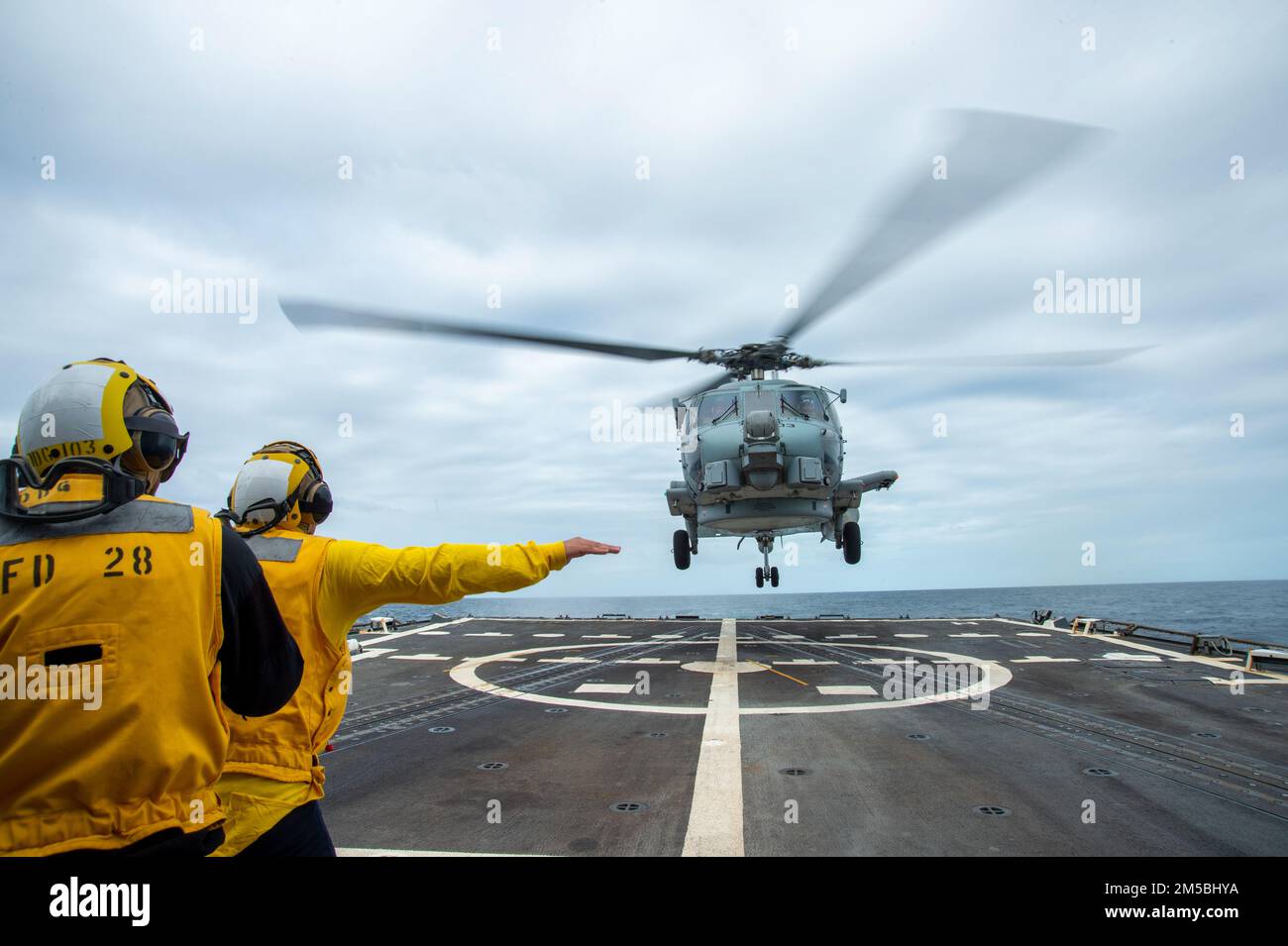 ATLANTIC OCEAN - Feb. 22, 2022 - Sailors direct an MH-60 Sea Hawk helicopter, attached to Helicopter Maritime Strike Squadron (HSM) 46, to land on the flight deck of the guided-missile destroyer USS Truxtun (DDG 103) while underway for Surface Warfare Advanced Tactical Training (SWATT). Truxtun is part of Destroyer Squadron (DESRON) 26 which supports Carrier Strike Group (CSG) 10. SWATT is led by the Naval Surface and Mine Warfighting Development Center (SMWDC) and is designed to increase warfighting proficiency, lethality and interoperability of participating units. Stock Photo