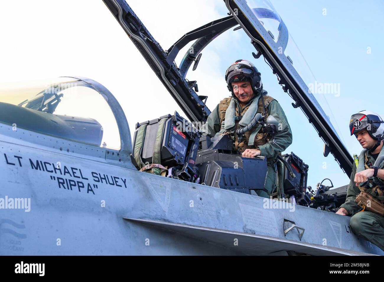 PHILIPPINE SEA (Feb. 23, 2022) Capt. Brian A. Ribota, commodore, Destroyer Squadron 21, enters an F/A-18F Super Hornet, assigned to the 'Black Aces' of Strike Fighter Squadron (VFA) 41, on the flight deck of the Nimitz-class aircraft carrier USS Abraham Lincoln (CVN 72). Abraham Lincoln Strike Group is on a scheduled deployment in the U.S. 7th Fleet area of operations to enhance interoperability through alliances and partnerships while serving as a ready-response force in support of a free and open Indo-Pacific region. Stock Photo
