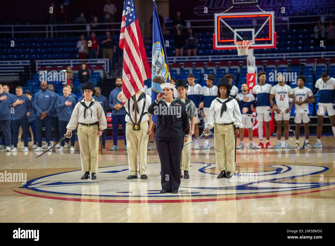 BOSTON (Feb 23, 2022 ) Sailors assigned to USS Constitution perform a color guard at the University of Southern Alabama basketball game as part of the Mobile Navy Week. USS Constitution, is the world’s oldest commissioned warship afloat, and played a crucial role in the Barbary Wars and the War of 1812, actively defending sea lanes from 1797 to 1855. During normal operations, the active-duty Sailors stationed aboard USS Constitution provide free tours and offer public visitation to more than 600,000 people a year as they support the ship’s mission of promoting the Navy’s history and maritime h Stock Photo