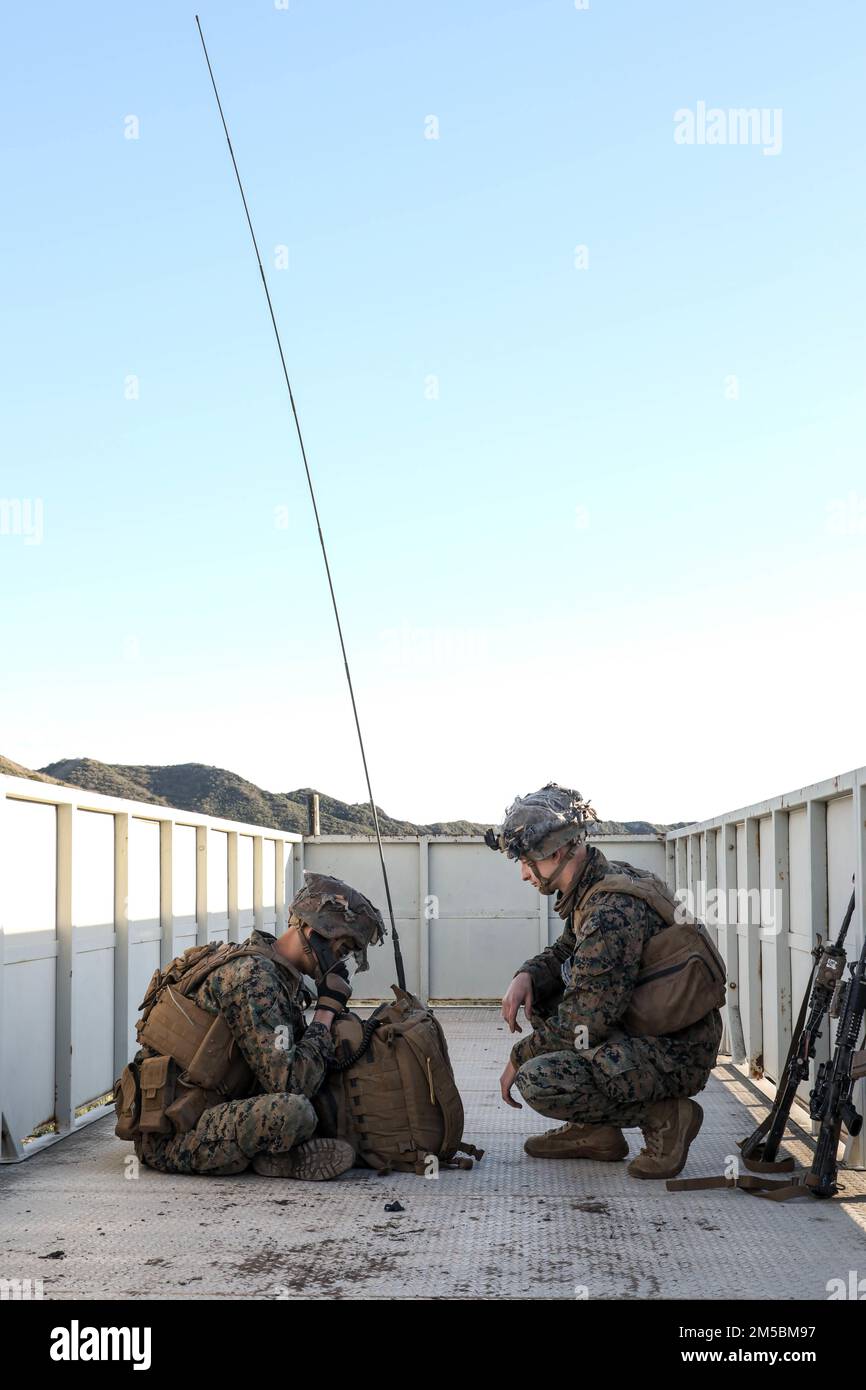 U.S Marine Corps Lance Cpl. Kole Haynes and Lance Cpl. William Gunn, both radio operators with Golf Co., 2d Battalion, 5th Marine Regiment (2/5), 1st Marine Division, set up an AN/PRC-117G radio on top of a roof at Marine Corps Base Camp Pendleton, California, Feb. 22, 2022. The Marines of 2/5 participated in an embassy reinforcement exercise organized by Expeditionary Operations Training Group in order to ensure Marines who are preparing to deploy are ready for complex combat situations. Stock Photo