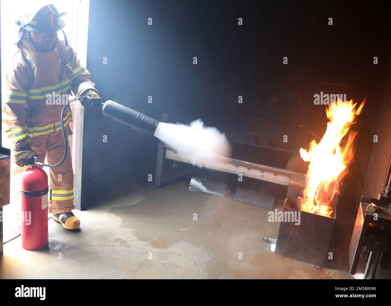 220223-N-OH262-0010--FORT EUSTIS, Va. (February 23, 2022)--A newly hired Civil Service Mariner (CIVMAR) uses a CO2 fire extinguisher to put out a simulated trash can fire at the Military Sealift Command Training Center East on Joint Base Langley-Fort Eustis, Virginia, Feb. 23. The training evolution was part of the MSC Basic Training Damage Control curriculum, which must be successfully completed prior to sailing in MSC's fleet of ships. Stock Photo