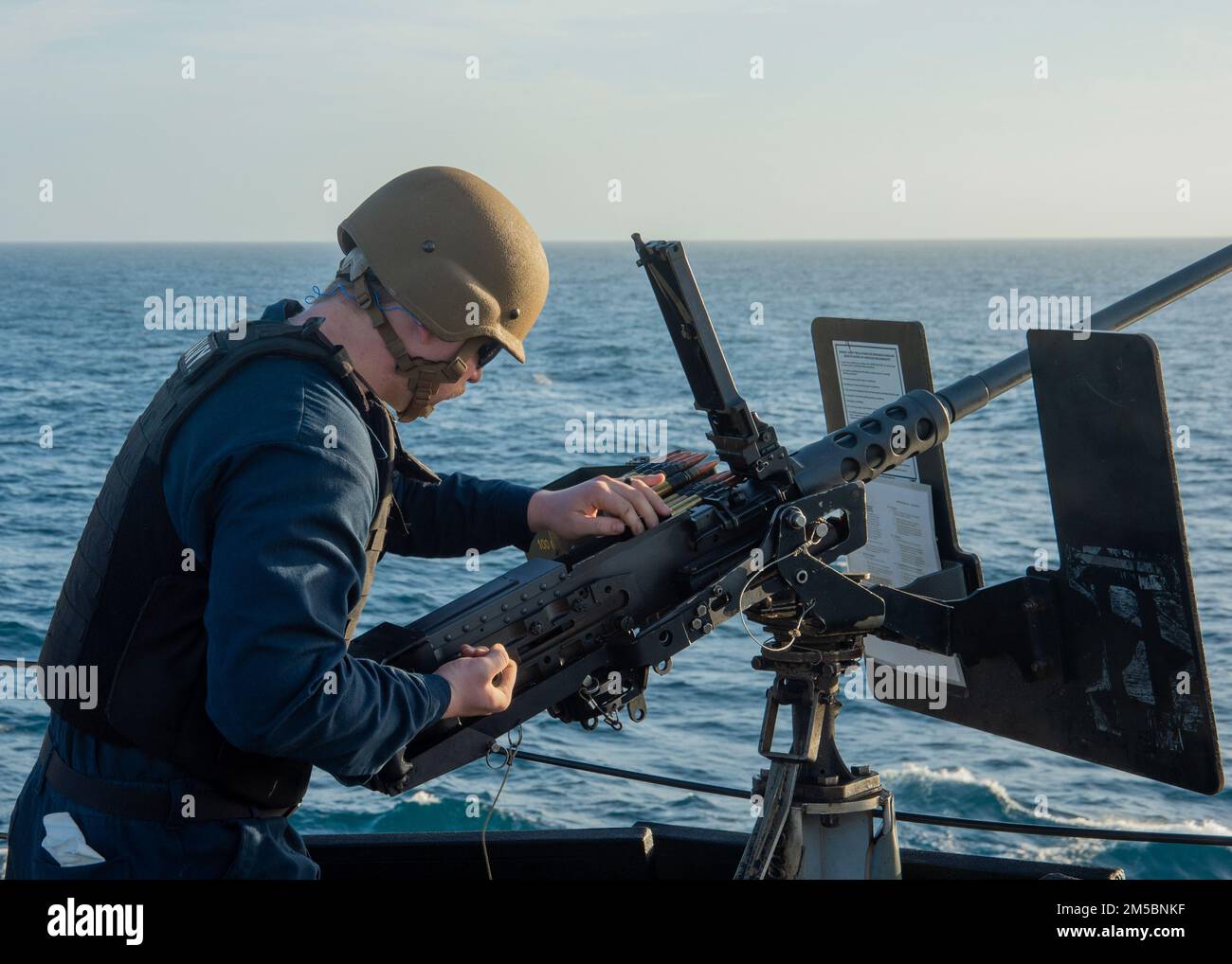 ATLANTIC OCEAN - Feb. 23, 2022 - Fire Controlman 2nd Class Devon Monroe performs a pre-fire check on a .50-caliber machine gun as part of the Surface Warfare Advanced Tactical Training (SWATT) exercise aboard the guided-missile destroyer USS Truxtun (DDG 103). Truxtun is part of Destroyer Squadron (DESRON) 26 which supports Carrier Strike Group (CSG) 10. SWATT is led by the Naval Surface and Mine Warfighting Development Center (SMWDC) and is designed to increase warfighting proficiency, lethality and interoperability of participating units. Stock Photo