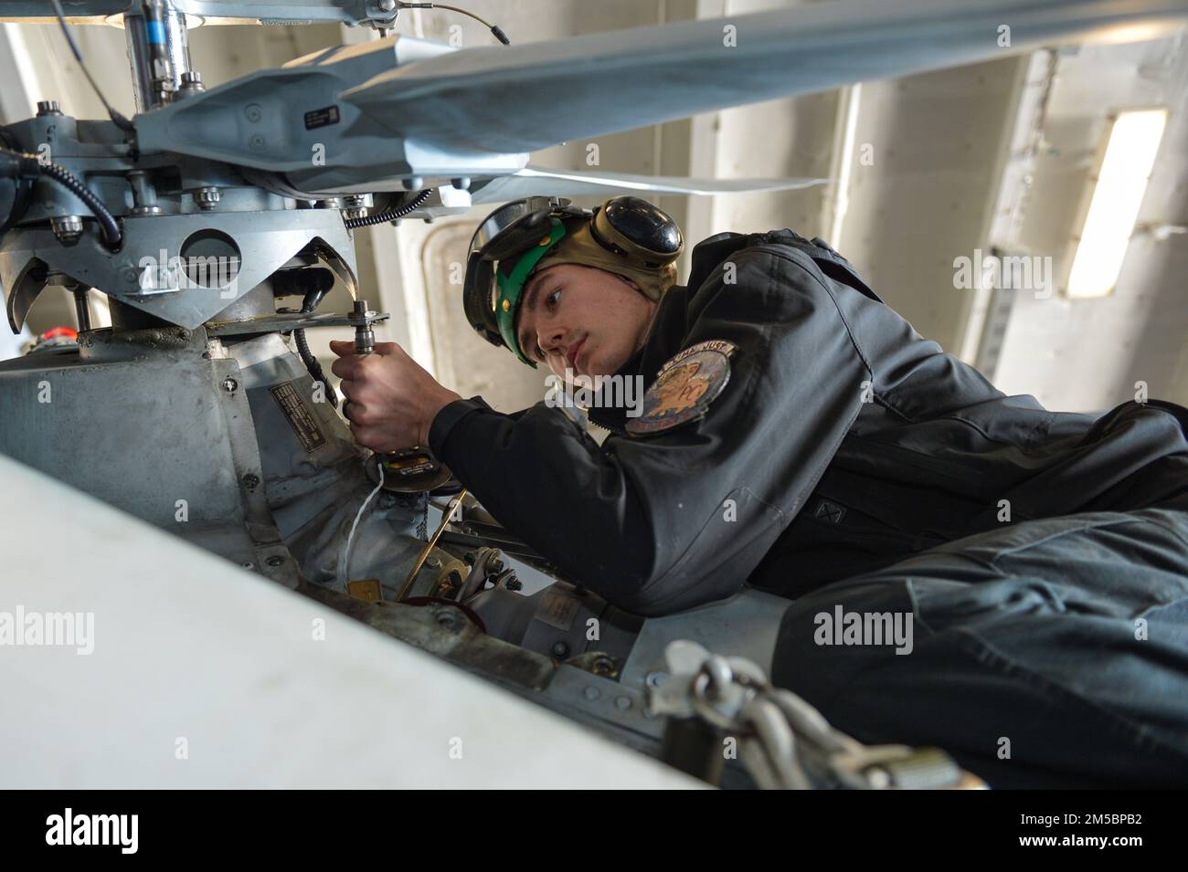 220224-N-GP384-1059 ADRIATIC SEA (Feb. 24, 2022) Aviation Electrician’s Mate 2nd Class William Lockwood, from Jacksonville, Florida, assigned to the 'Proud Warriors' of Helicopter Maritime Strike Squadron (HSM) 72, examines a cable for corrosion on an MH-60R Sea Hawk helicopter in the hangar bay of the Nimitz-class aircraft carrier USS Harry S. Truman (CVN 75), Feb. 24, 2022. The Harry S. Truman Carrier Strike Group is on a scheduled deployment in the U.S. Sixth Fleet area of operations in support of U.S., allied and partner interests in Europe and Africa. Stock Photo