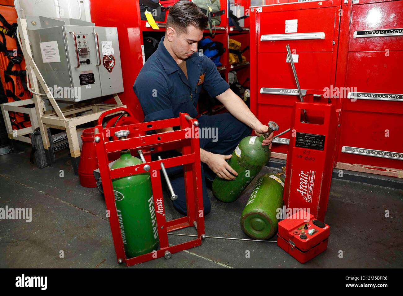 PHILIPPINE SEA (Feb. 24, 2022) Damage Controlman Fireman Pedro Lozano, from San Diego, inspects a portable exothermic cutting unit (PECU) in a repair locker aboard the Nimitz-class aircraft carrier USS Abraham Lincoln (CVN 72). Abraham Lincoln Strike Group is on a scheduled deployment in the U.S. 7th Fleet area of operations to enhance interoperability through alliances and partnerships while serving as a ready-response force in support of a free and open Indo-Pacific region. Stock Photo