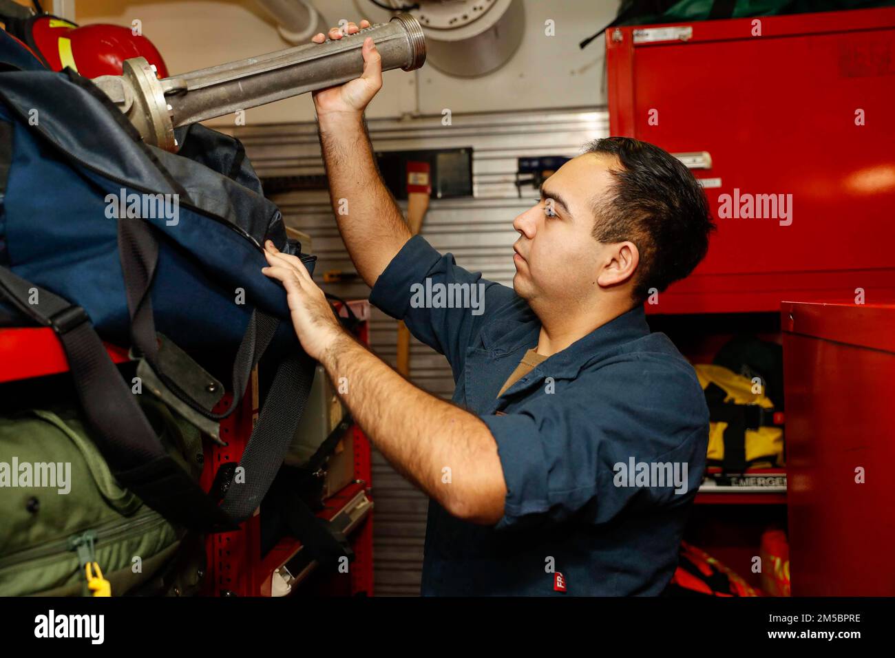 PHILIPPINE SEA (Feb. 24, 2022) Damage Controlman Fireman John Mancia, from Dallas, takes inventory of dewatering equipment in a repair locker aboard the Nimitz-class aircraft carrier USS Abraham Lincoln (CVN 72). Abraham Lincoln Strike Group is on a scheduled deployment in the U.S. 7th Fleet area of operations to enhance interoperability through alliances and partnerships while serving as a ready-response force in support of a free and open Indo-Pacific region. Stock Photo