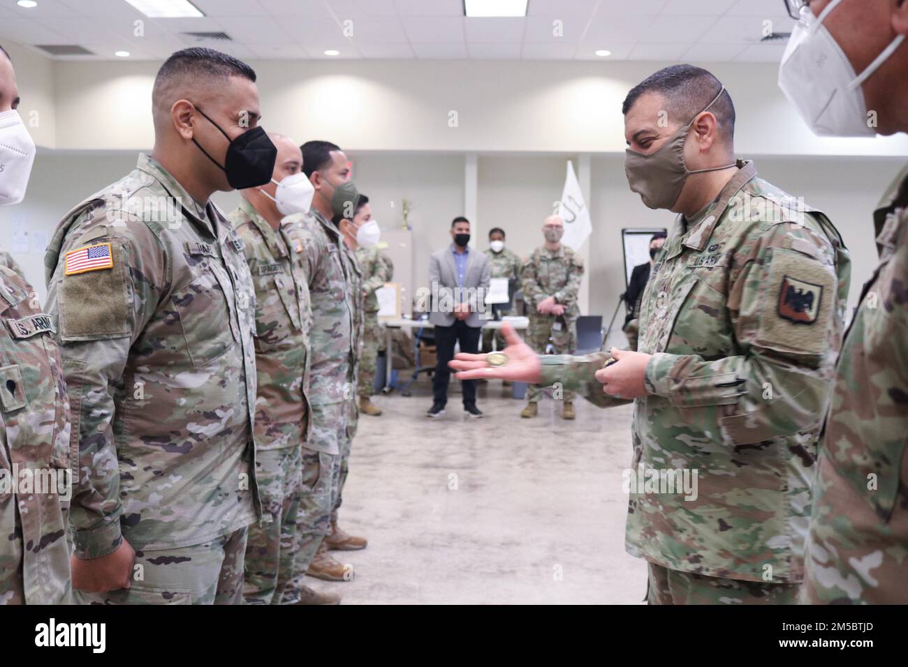 Maj. Gen. John C. Andonie, deputy director of the Army National Guard, extends his hand with a coin of excellence to recognize Sgt. Gamaliel Tavárez for standing out in his tasks as operation noncommissioned officer in different missions of the Joint Task Force - Puerto Rico at Fort Buchanan, Puerto Rico, Feb. 24, 2022. Sgt. Gamaliel Tavárez was in charge to open 40 testing sites around the island to detect COVID-19 positive cases to ensure the citizens’ health and safety and was the operation sergeant of the mass vaccination sites as part of Operation Warp Speed. Stock Photo