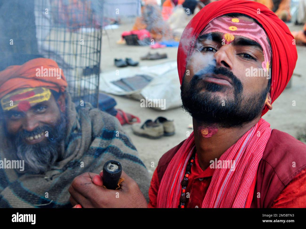 A Shaivite sadhu smoking chillum on the Mallick Ghat by the Hooghly river in Kolkata, India. Stock Photo