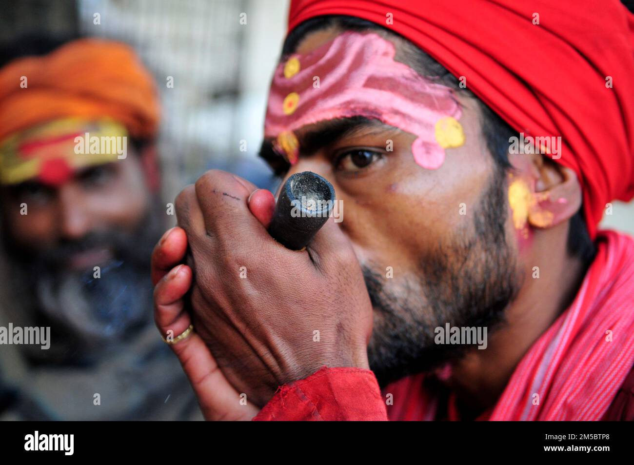 A Shaivite sadhu smoking chillum on the Mallick Ghat by the Hooghly river in Kolkata, India. Stock Photo