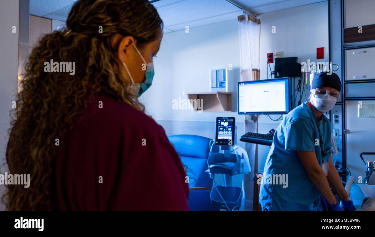 YUMA, AZ -- U.S. Air Force Senior Airman Katsiaryna Nelipovich, right, a medical technician from Eglin Air Force Base, speaks with Daniela Valencia, left, a patient care assistant working at Yuma Regional Medical Center, as she checks a civilian patient’s vitals in Yuma, Arizona, on Feb. 24, 2022.  The U.S. Airmen are deployed in support of the continued Department of Defense COVID response operations to help communities in need. U.S. Northern Command, through U.S. Army North, remains committed to providing flexible Department of Defense support to the whole-of-government COVID response. Stock Photo