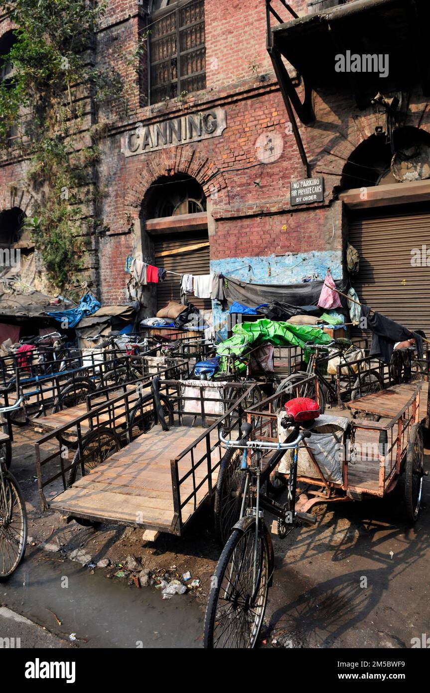 Rickshaws parking by an old British built building in central Kolkata, India. Stock Photo