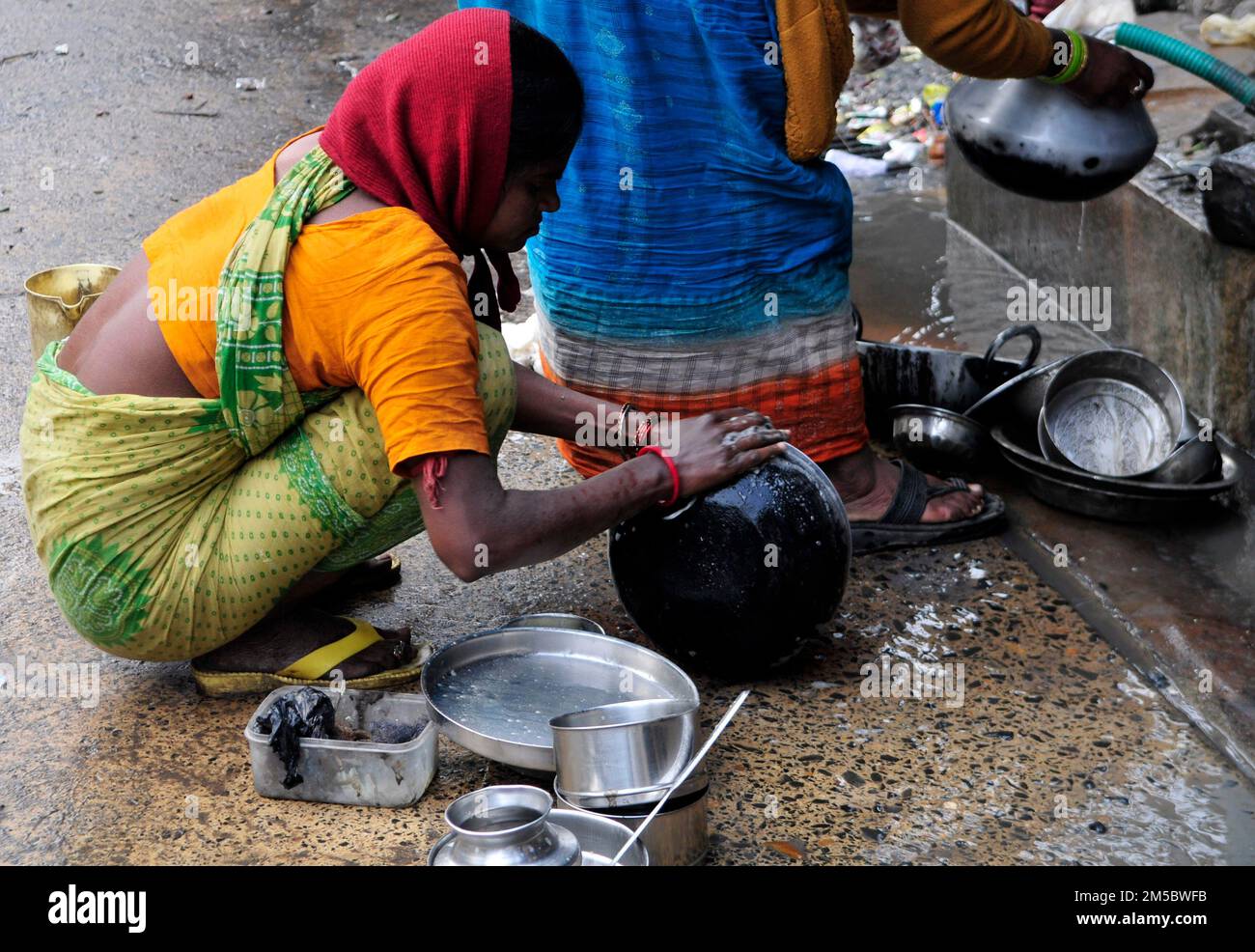 Bengali women Washing dishes on the street. Kolkata, India. Stock Photo