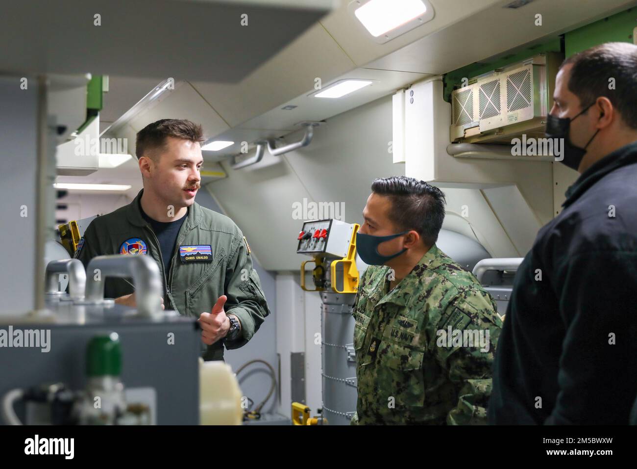 NAVAL AIR FACILITY ATSUGI, Japan (Feb. 24, 2022) –  Naval Air Crewman (Operator) 2nd Class Chris Ubaldo, from Goshen, Indiana, assigned to the “Golden Swordsmen” of Patrol Squadron (VP) 47, gives a tour to personnel from Commander, Submarine Group (CSG) 7 while aboard a P-8A Poseidon familiarization flight, Feb. 24. VP-47 is currently deployed to NAF Misawa, Japan conducting maritime patrol and reconnaissance and theater outreach operations within the U.S. 7th Fleet (C7F) area of operations in support of Commander, Task Force 72, C7F, and U.S. Indo-Pacific Command objectives throughout the reg Stock Photo