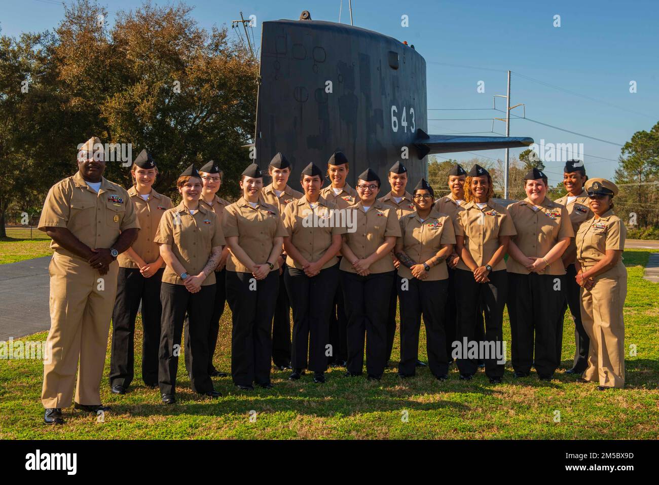 KINGS BAY, Ga. (Feb. 24, 2022) Master Chief Sonar Technician (Submarines) Myron Williams, chief of the boat of the Ohio-class ballistic-missile submarine USS Wyoming (SSBN 742), stands with the enlisted women assigned to the ship’s Blue Crew at the USS Bancroft static display outside of the gate at Naval Submarine Base Kings Bay, Georgia. The 15 female submariners recently made history when they became the first enlisted female crew to complete a ballistic-missile submarine deterrent patrol. Wyoming is homeported at the base which is home to all East Coast Ohio-class submarines. Stock Photo