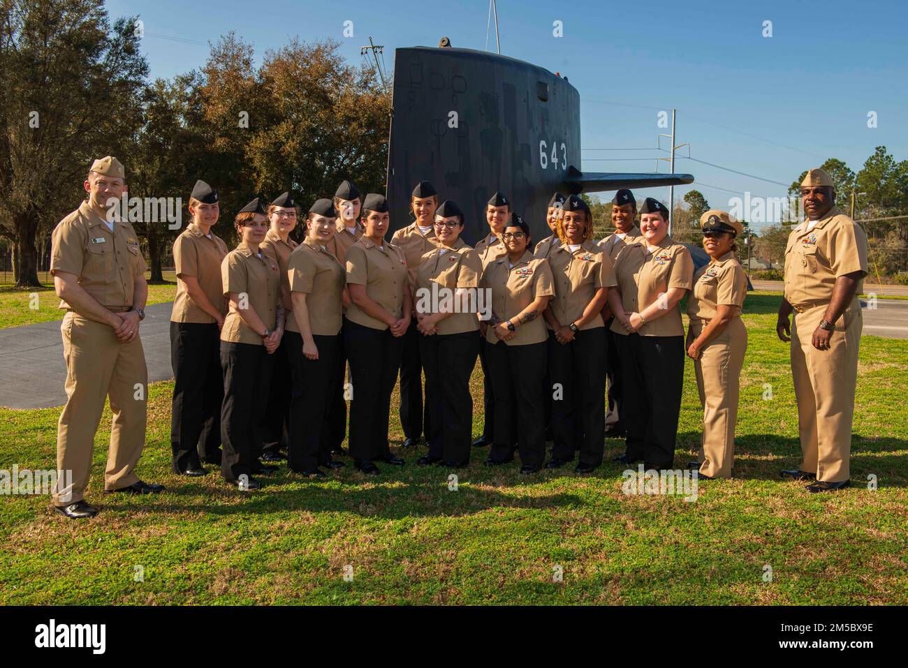 KINGS BAY, Ga. (Feb. 24, 2022) Lt. Cmdr. Jeremy Carroll (left), executive officer of the Ohio-class ballistic-missile submarine USS Wyoming (SSBN 742), and Master Chief Sonar Technician (Submarines) Myron Williams (right), chief of the boat, stand with the enlisted women assigned to the ship’s Blue Crew at the USS Bancroft static display outside of the gate at Naval Submarine Base Kings Bay, Georgia. The 15 female submariners recently made history when they became the first enlisted female crew to complete a ballistic-missile submarine deterrent patrol. Wyoming is homeported at the base which Stock Photo