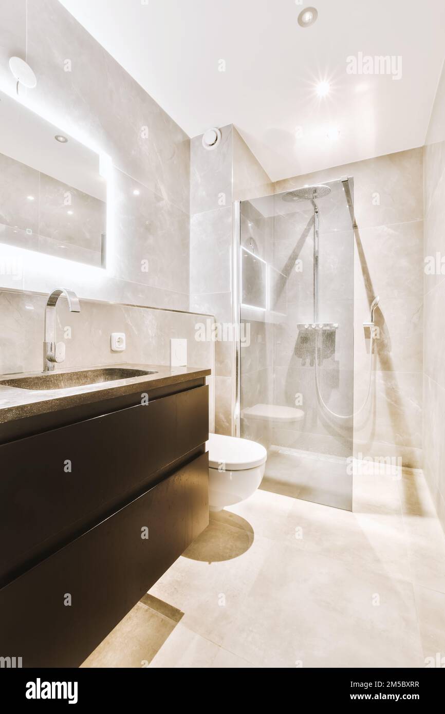 a modern bathroom with white marble walls and flooring, along with a ...