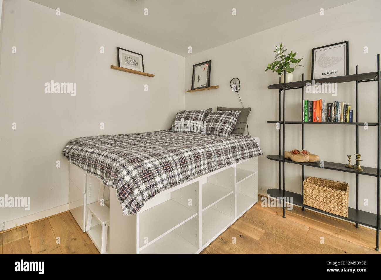 a bedroom with a bed, shelves and books on the wall behind it is a book