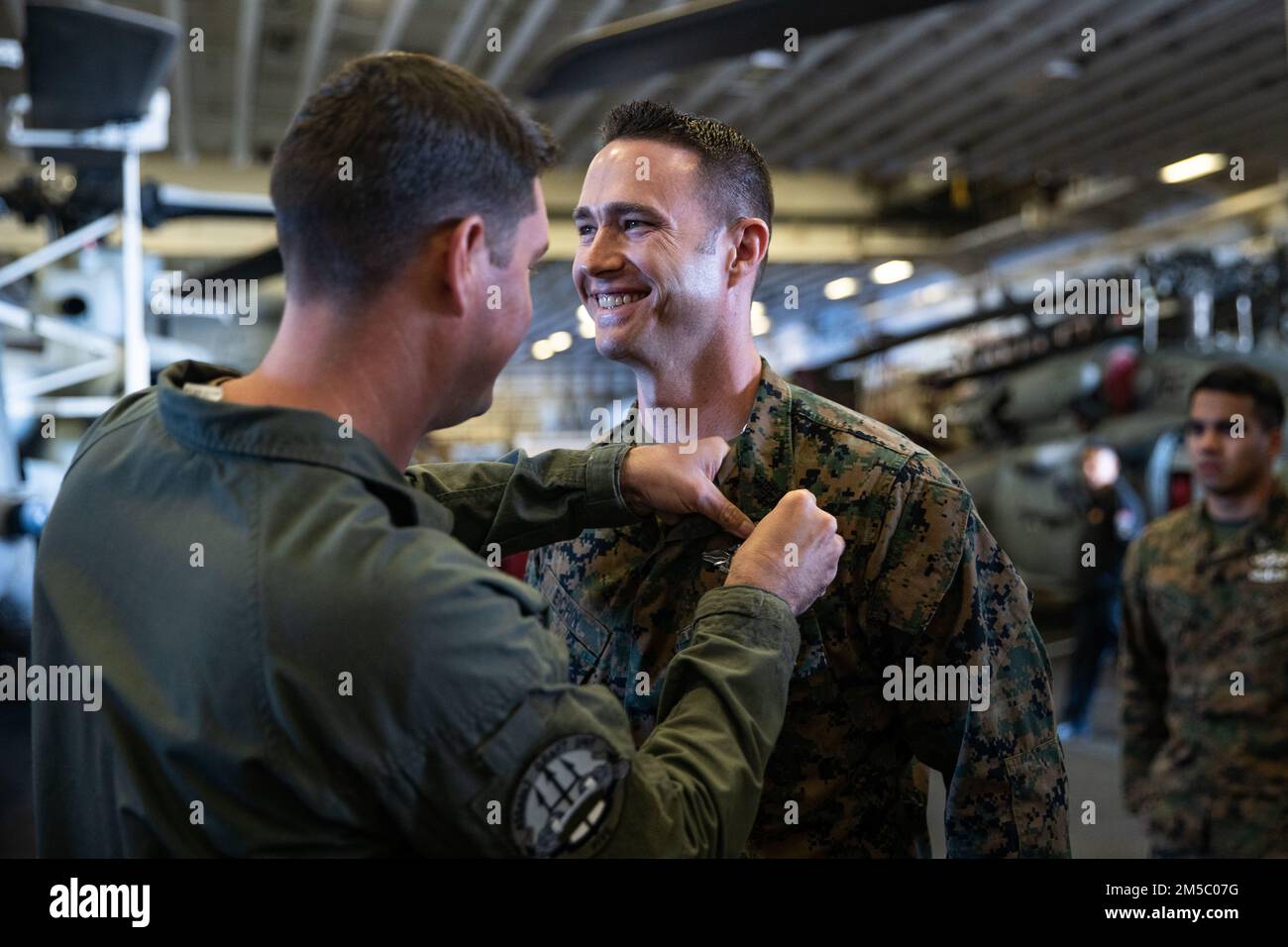 PACIFIC OCEAN (Feb. 24, 2022) U.S. Navy Hospital Corpsman Senior Chief Petty Officer, Chad Eichin, the 11th Marine Expeditionary Unit (MEU) Navy senior enlisted leader, assigned to the 11th MEU, receives his enlisted surface warfare specialist pin aboard the Wasp-class amphibious assault ship USS Essex (LHD 2), Feb. 24. Marines and Sailors of the 11th MEU and Essex Amphibious Ready Group are underway conducting routine operations in U.S. 3rd Fleet. Stock Photo