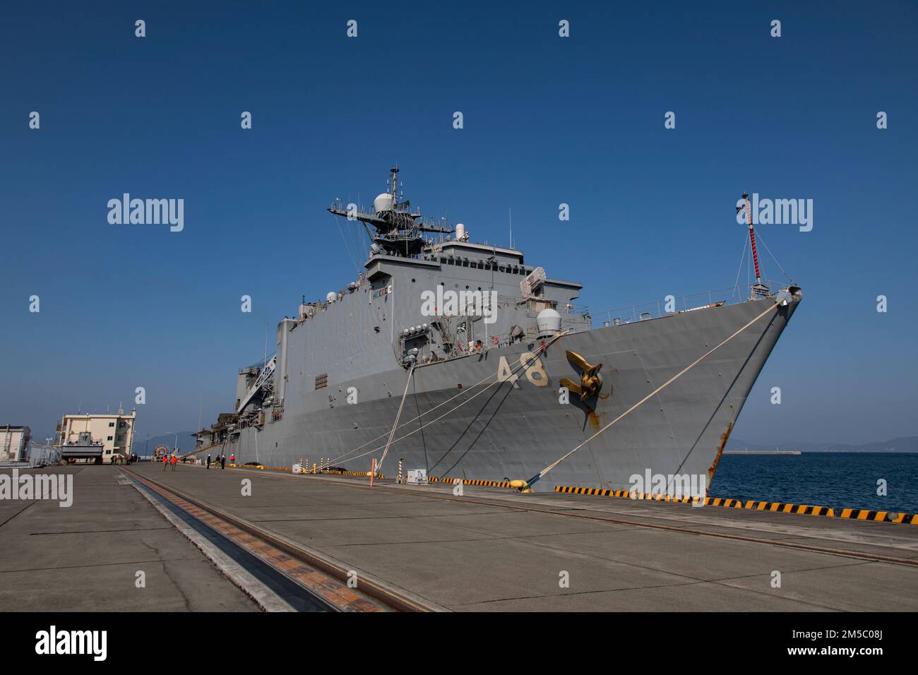The amphibious dock landing ship USS Ashland (LSD 48) pulls into the harbor at Marine Corps Air Station Iwakuni, Japan, Feb. 25, 2022. The Ashland, part of the U.S. Expeditionary Strike Group, with the 31st MEU embarked, is homeported in Sasebo, Japan, and visited MCAS Iwakuni to conduct logistical onload and offload in support of MEU operations. With a collocated airfield and harbor, MCAS Iwakuni is uniquely postured to provide advanced naval support to maintain regional security, peace, and stability. Stock Photo