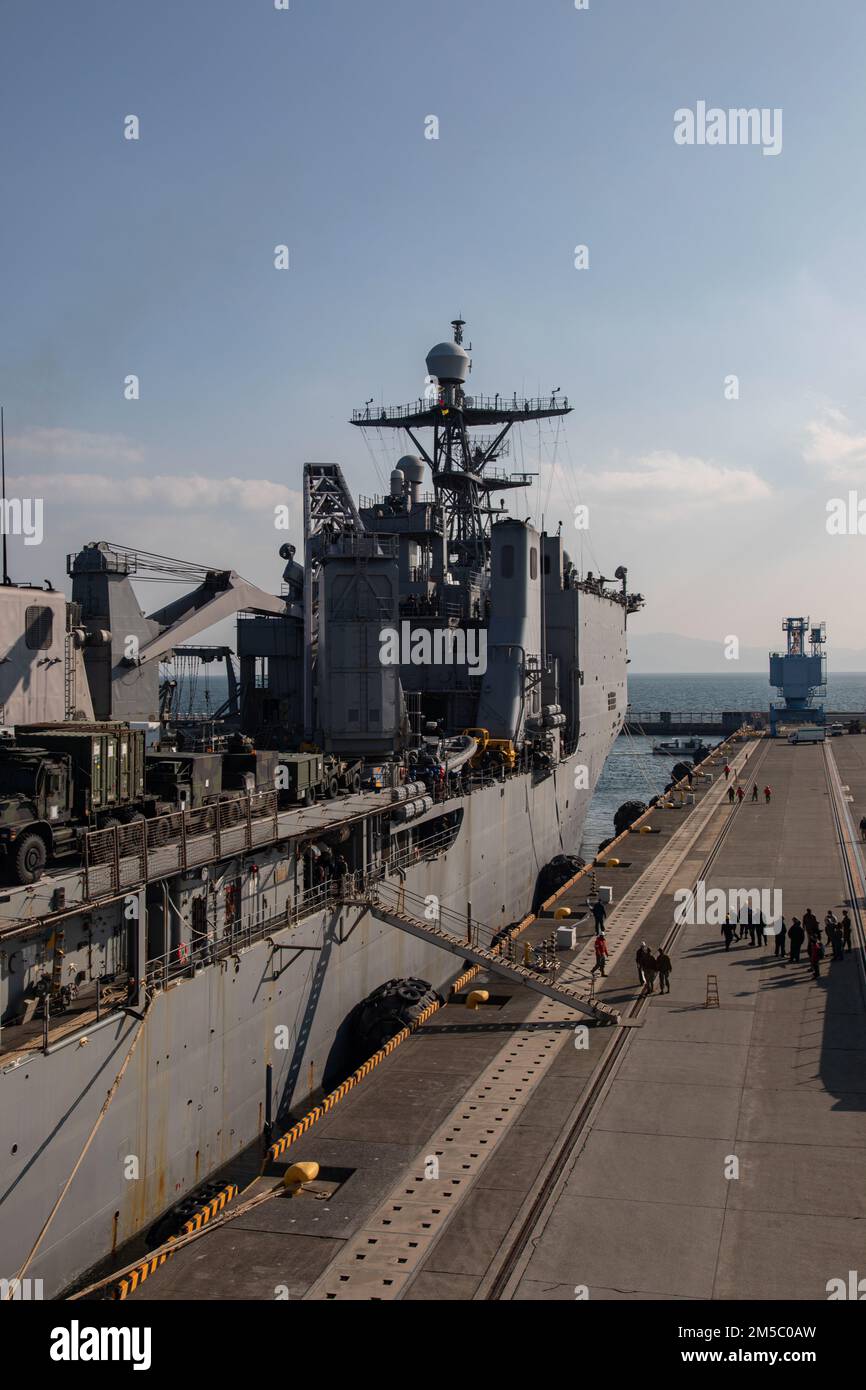 The amphibious dock landing ship USS Ashland (LSD 48) pulls into the harbor at MCAS Iwakuni, Japan, Feb. 25, 2022. The Ashland, part of the U.S. Expeditionary Strike Group, with the 31st MEU embarked, is homeported in Sasebo, Japan, and visited MCAS Iwakuni to conduct logistical onload and offload in support of MEU operations. With a collocated airfield and harbor, MCAS Iwakuni is uniquely postured to provide advanced naval support to maintain regional security, peace, and stability. Stock Photo