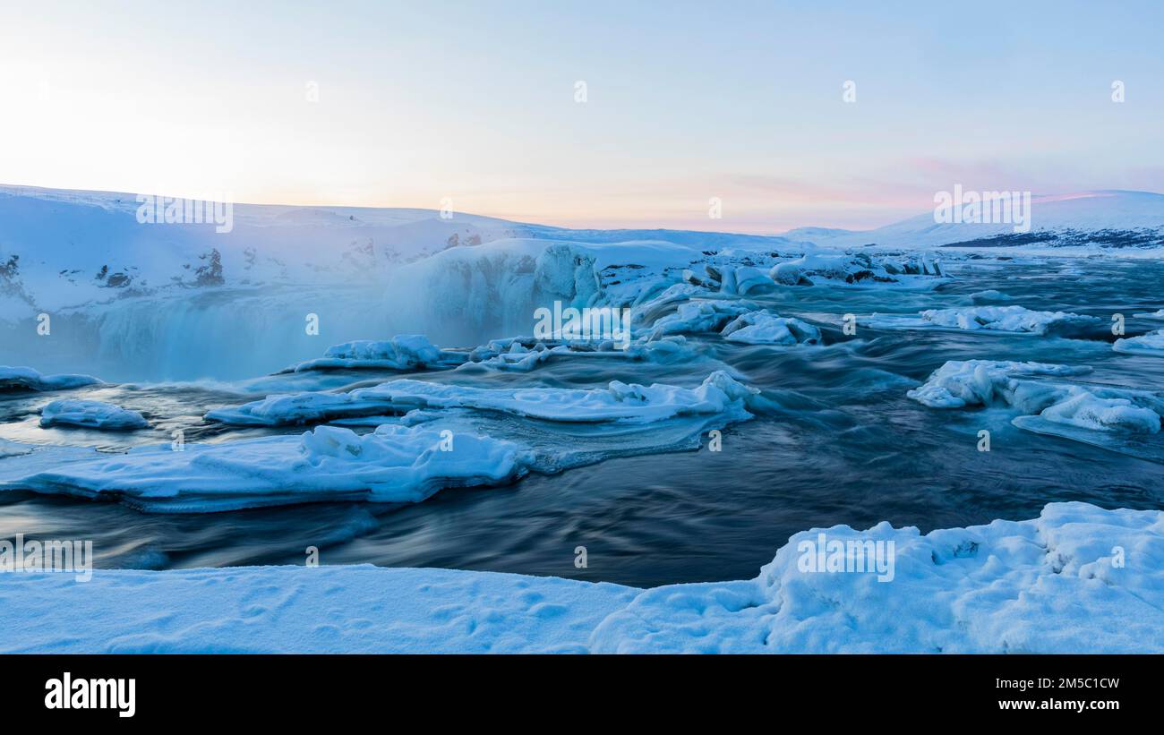 Icefall at the edge of the Godafoss waterfall at dawn, snow-covered landscape, Northern Iceland Eyestra, Iceland Stock Photo