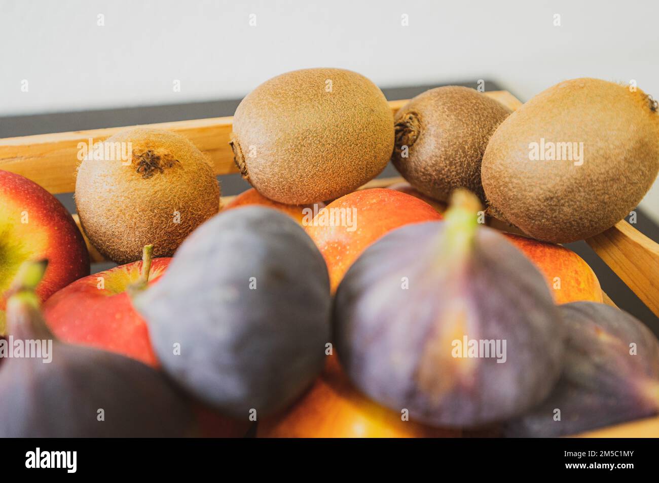 Apples, kiwi and fig in a wooden fruit basket as a healthy meal