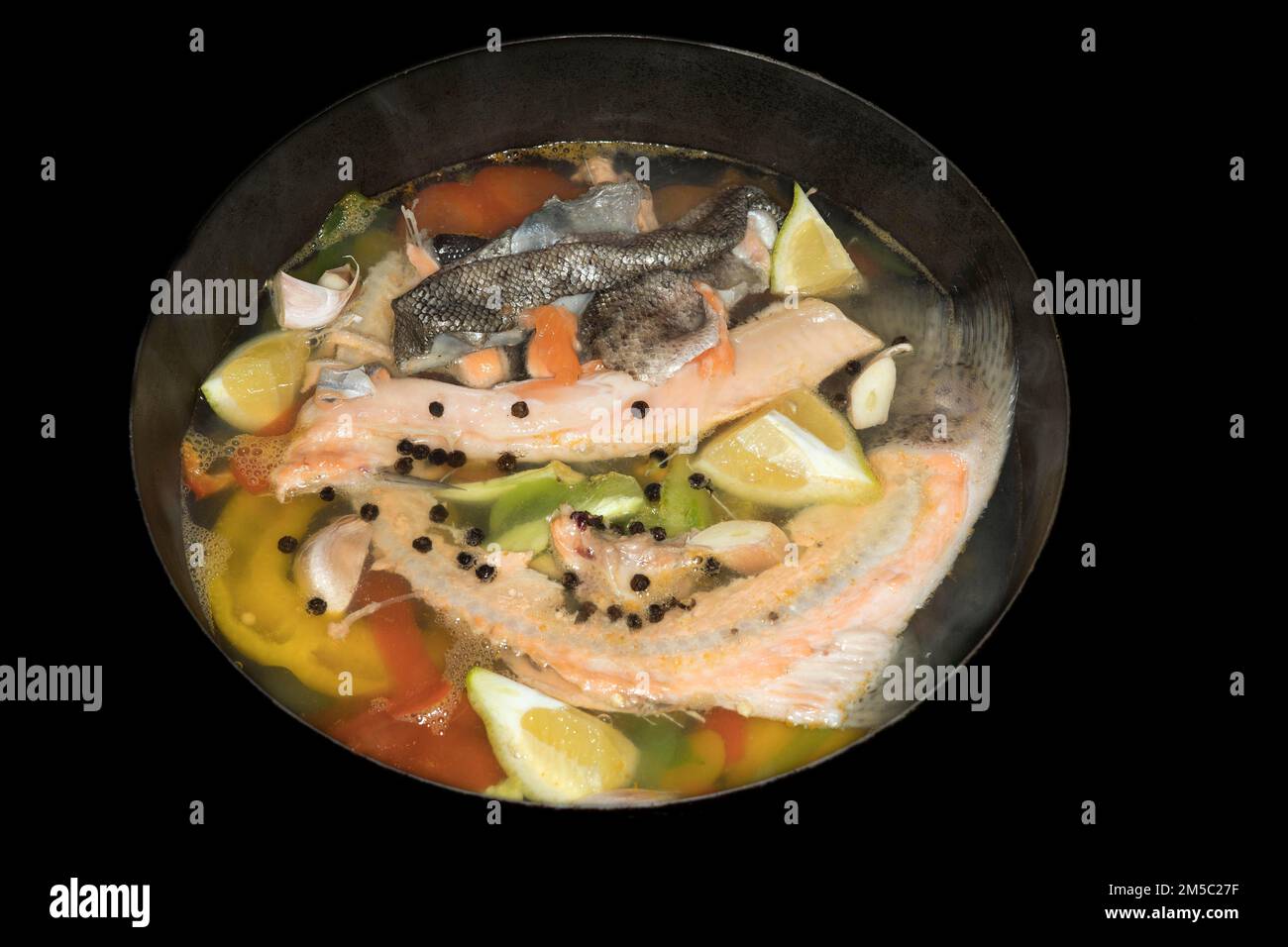 Cooked Fish Stock Cooked fish stock of a salmon trout with lemons, peppercorns and ...