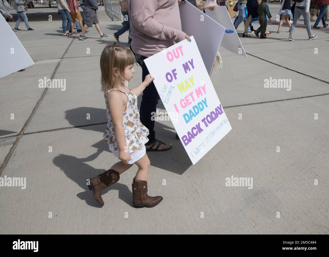 A child holds a sign while waiting for Marines with Marine Attack Squadron (VMA) 214, 11th Marine Expeditionary Unit, to return during a homecoming event located at Marine Corps Air Station Yuma, Arizona, Feb. 27, 2022. VMA-214, the fixed squadron for the 11th MEU, returned from the unit’s Western Pacific 21.2 deployment in support of U.S. 3rd, 5th, and 7th Fleet area of operations as part of the Essex Amphibious Ready Group. Stock Photo