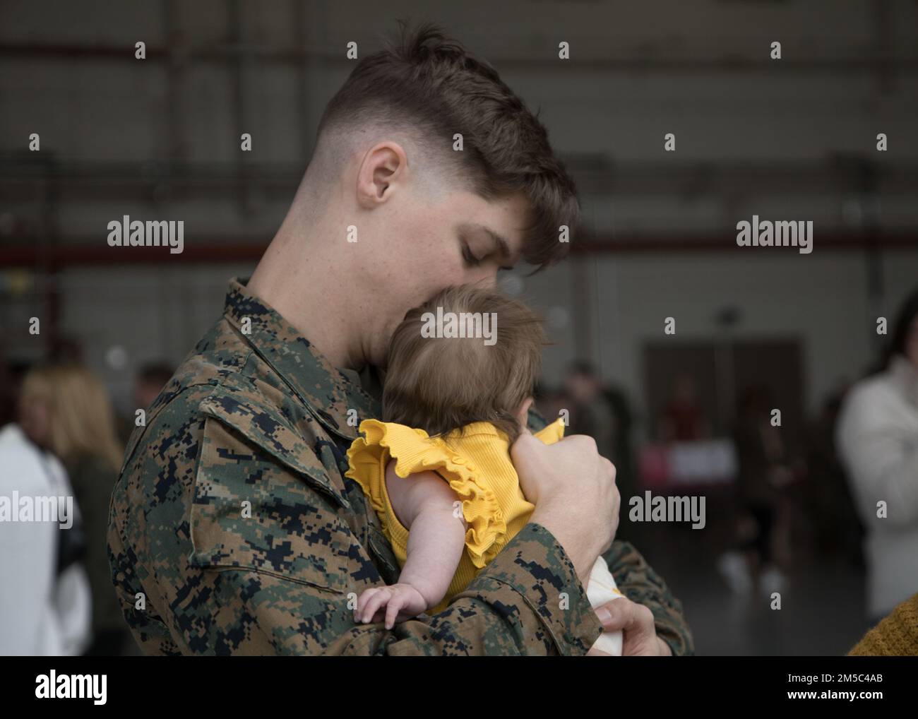 A U.S. Marine with Marine Attack Squadron (VMA) 214, 11th Marine Expeditionary Unit, reunites with his child during a homecoming event located at Marine Corps Air Station Yuma, Arizona, Feb. 27, 2022. VMA-214, the fixed squadron for the 11th MEU, returned from the unit’s Western Pacific 21.2 deployment in support of U.S. 3rd, 5th, and 7th Fleet area of operations as part of the Essex Amphibious Ready Group. Stock Photo