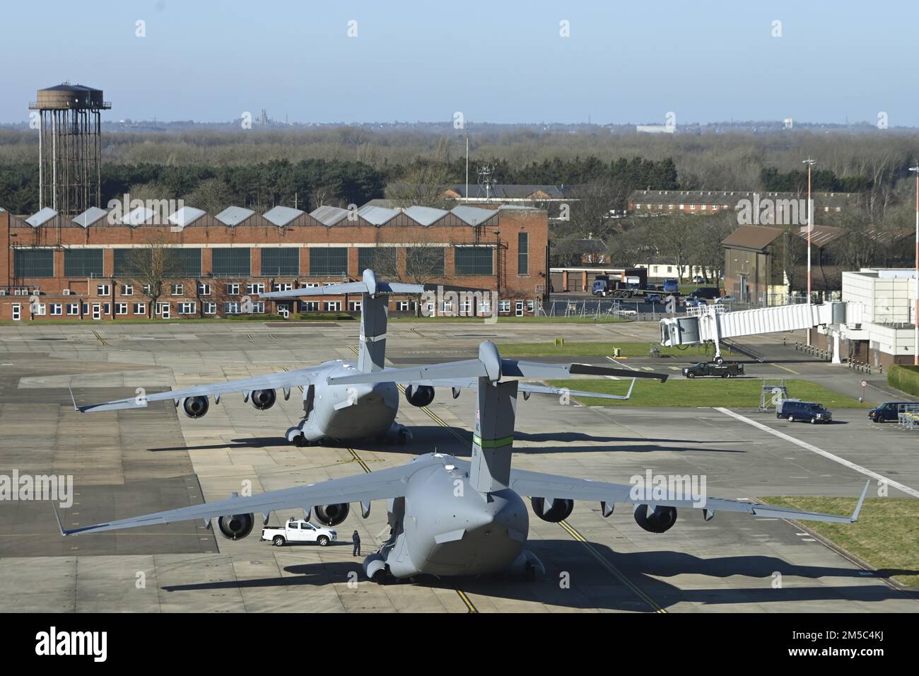 Two U.S. Air Force C-17 Globemaster III aircraft assigned to the 60th Air Mobility Wing, Travis Air Force Base, Calif., and the 62nd Airlift Wing, Joint Base Lewis-McChord, Wash., sit on the flightline after landing at Royal Air Force Mildenhall, England, Feb. 27, 2022. The aircraft landed at RAF Mildenhall after transporting cargo pallets to an air base in Norway. Stock Photo
