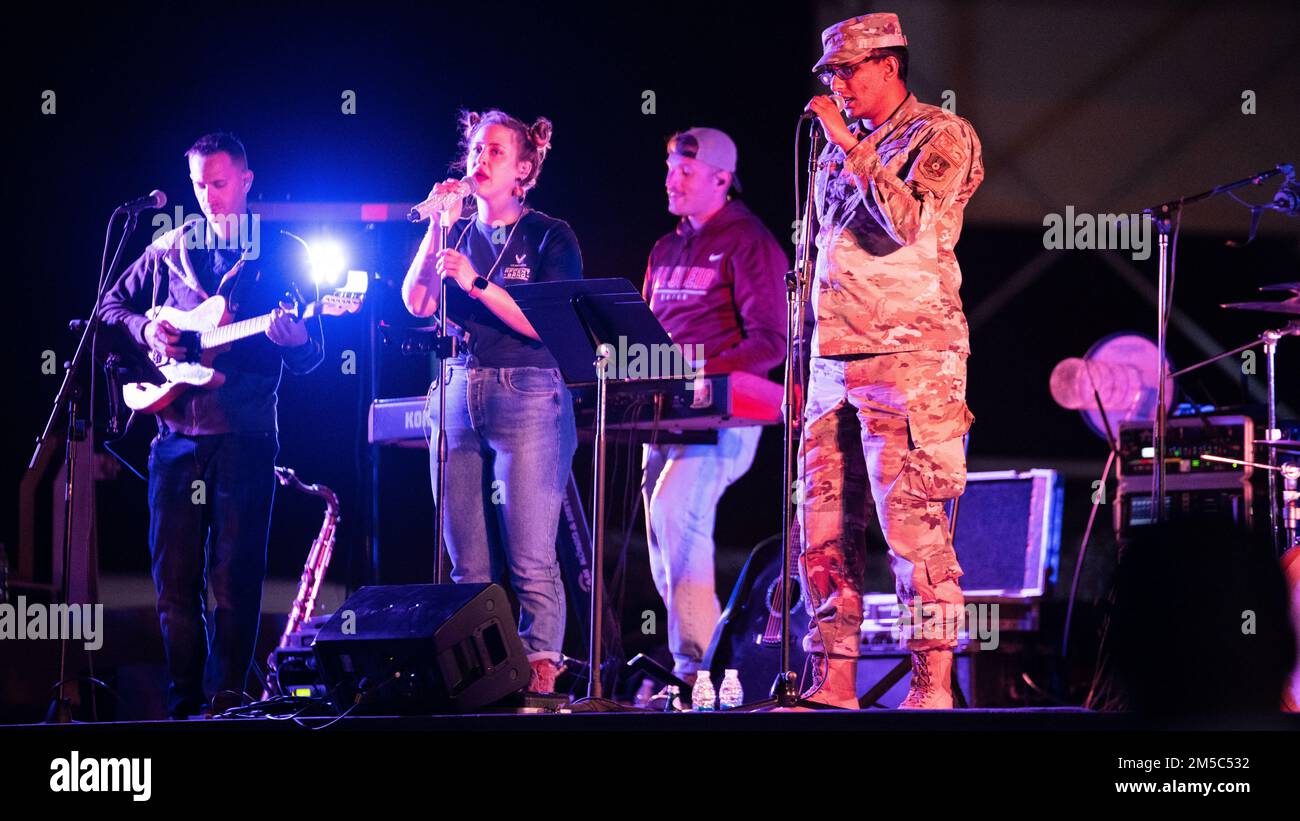 U.S. Air Force Senior Airman Ashish Naik, 378th Expeditionary Communication Squadron, client systems technician, performs alongside the U.S. Air Forces Central Band during a live band karaoke concert at Prince Sultan Air Base, Kingdom of Saudi Arabia, Feb. 27, 2022. The AFCENT Band is the only permanently assigned Air Force Band to the Central Command Area of Responsibility. Stock Photo