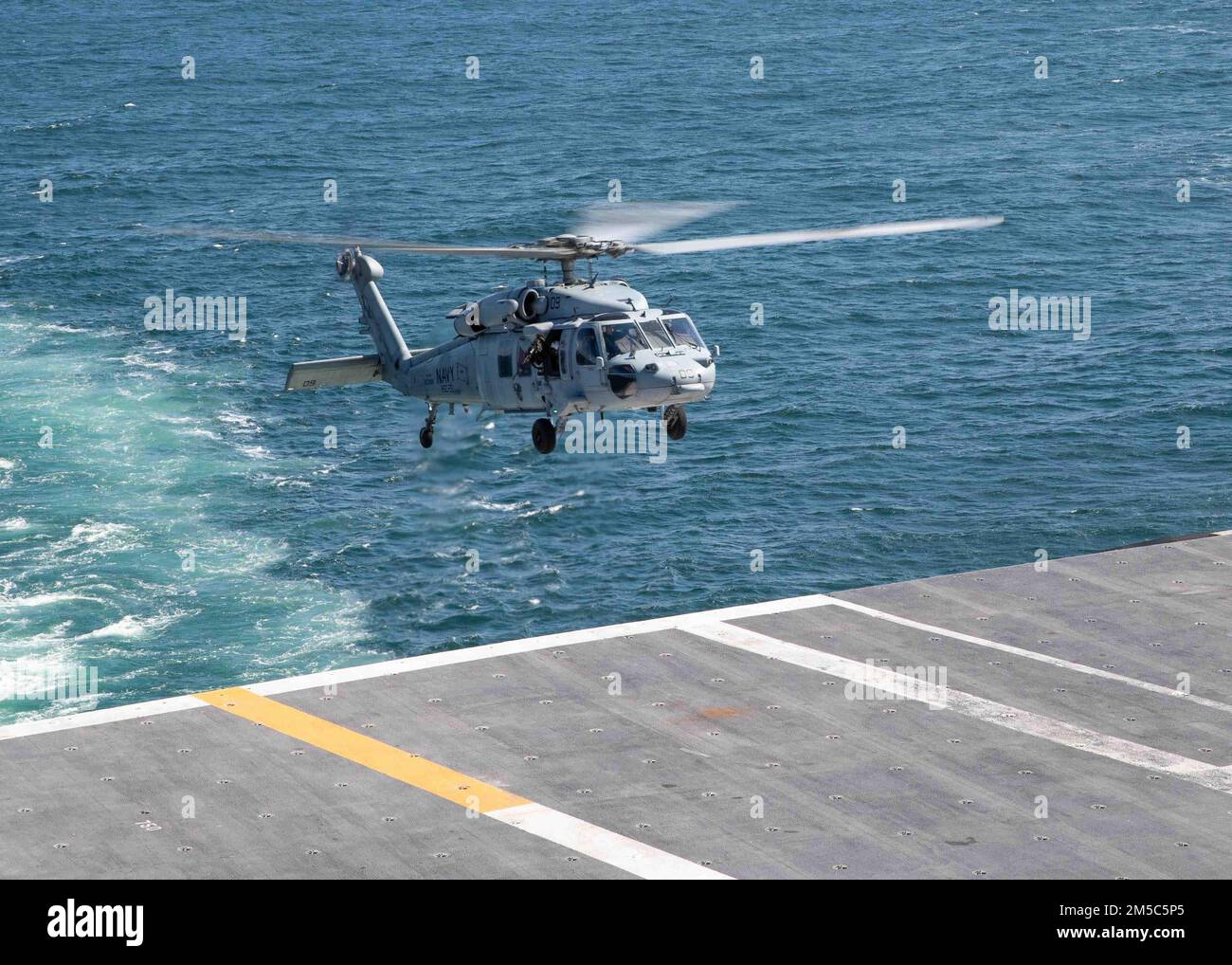 An MH-60S Sea Hawk helicopter attached to the “Knights” of Helicopter Sea Combat Squadron (HSC) 22 takes off of the flight deck of USS Gerald R. Ford (CVN 78), Feb. 28, 2022. Ford is underway in the Atlantic Ocean after completing the industrial portion of a six-month Planned Incremental Availability (PIA). Stock Photo