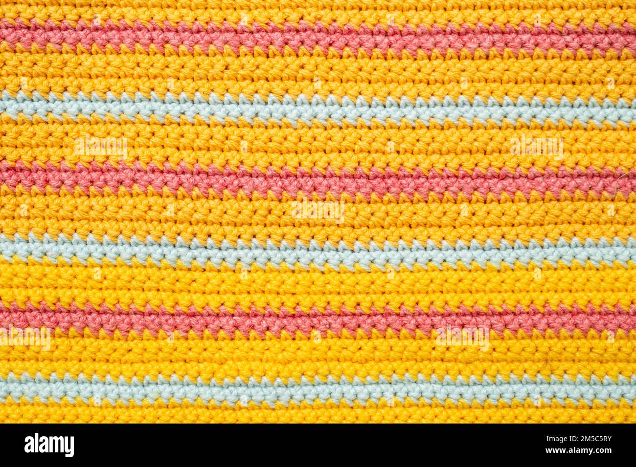 horizontal orange pink and blue crochet lines pattern, close up ...