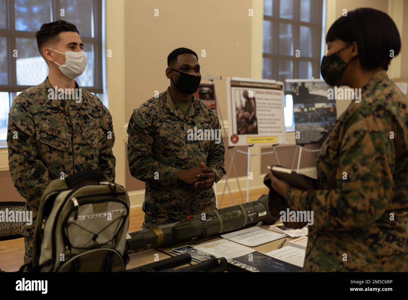 U.S Marine Corps Cpl. Richard Gillis, left, and Cpl. Olorunfemi Akintoye, both assistant trainers at the sim center, Marine Corps Base Camp Lejeune, speak with Lt. Col. NaTasha Everly, commanding officer of weapons training battalion, Stone Bay, Marine Corps Base Camp Lejeune (MCB Camp Lejeune) during the warfighter training symposium event at Marston Pavilion, MCB Camp Lejeune, North Carolina, Feb. 28, 2022. The warfighter training symposium educated unit leaders across MCB Camp Lejeune on range modernization efforts, development of new ranges and highlighted other training opportunities and Stock Photo