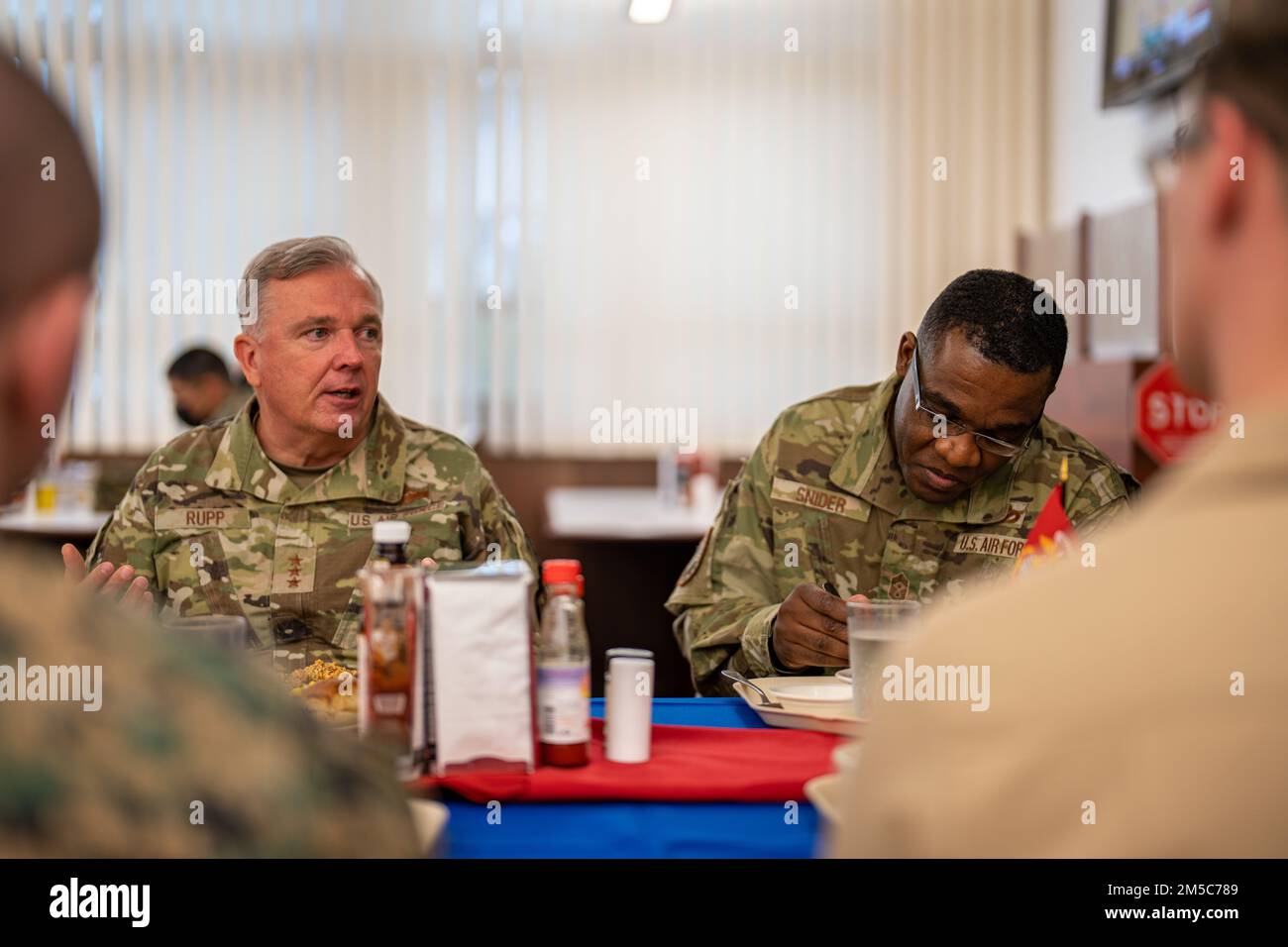 U.S. Air Force Lt Gen. Ricky N. Rupp, the commander of United States Forces Japan, and Chief Master Sgt. Wendell J. Snider, the USFJ command senior enlisted leader, have lunch with noncommissioned officers during their visit at Marine Corps Air Station Iwakuni, Japan, March 1, 2022. Rupp visited squadrons and spoke with service members of all ranks at MCAS Iwakuni to better understand the air station’s commitment to the U.S.-Japan alliance and level of military readiness. MCAS Iwakuni is an advanced naval base which provides positional advantage, strengthened strategic alliances, and support t Stock Photo