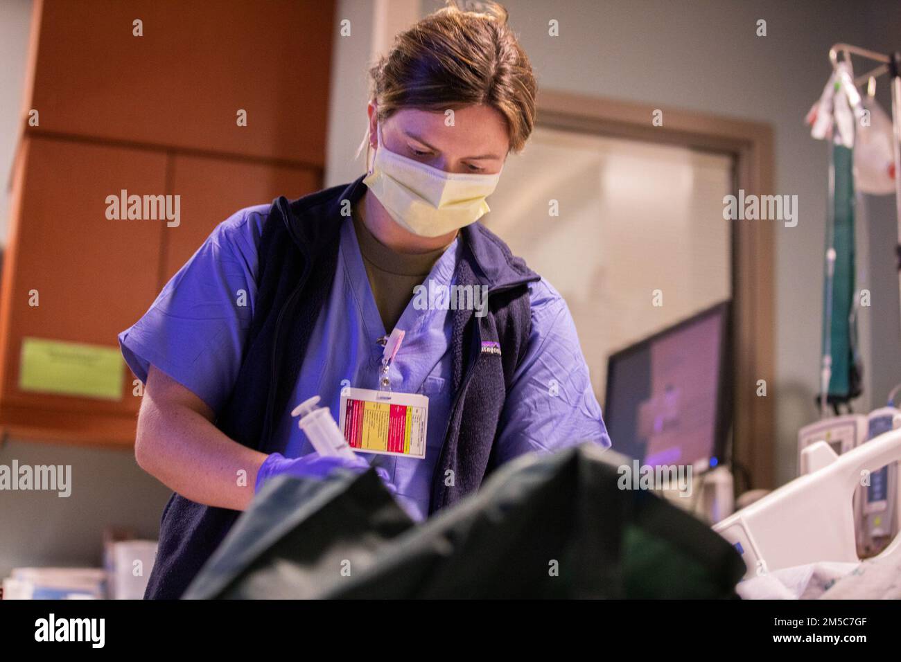 LANSING, Mich. -- U.S. Army 2nd Lt. Grace Sullivan, a military medical team registered nurse assigned to Tripler Army Medical Center in Honolulu, administers medicine to a patient at Sparrow Hospital in Lansing, Michigan, Feb. 28, 2022. U.S. Northern Command, through U.S. Army North, remains committed to providing flexible Department of Defense support to the whole-of-government COVID response. Stock Photo