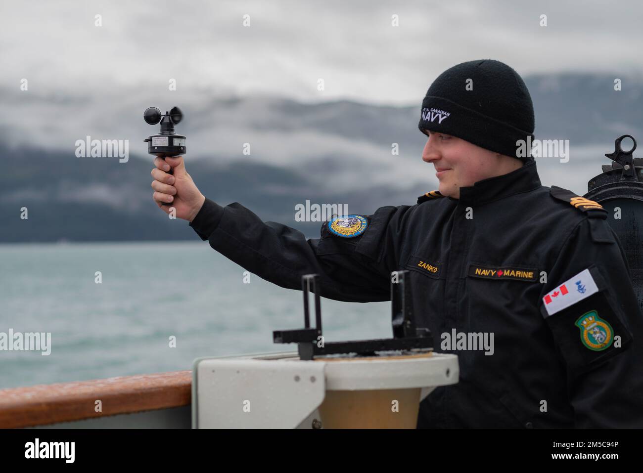 Sub-lieutenant Nick Zanko measures wind speed using a handheld anemometer on board Her Majesty's Canadian Ship Brandon during the entrance of Juneau, Alaska, Feb. 28, 2022. Canadian Armed Forces are participating in Exercise ARCTIC EDGE 2022, a U.S. Northern Command biennial exercise designed to demonstrate and exercise the ability to rapidly deploy and operate in the Arctic.Photo: Lieutenant (N) Pamela Hogan Stock Photo