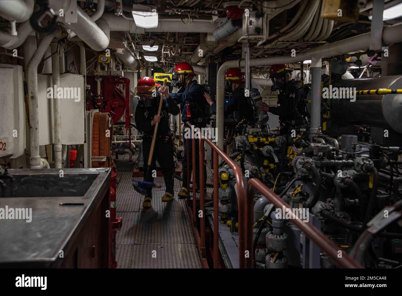220225-N-XB010-1001 PACIFIC OCEAN (Feb. 25, 2022) Sailors assigned to USS New Orleans (LPD 18) overhaul an engine space during a fire drill. New Orleans, part of the America Amphibious Ready Group, along with the 31st Marine Expeditionary Unit, is operating in the U.S. 7th Fleet area of responsibility to enhance interoperability with allies and partners and serve as a ready response force to defend peace and stability in the Indo-Pacific region. Stock Photo
