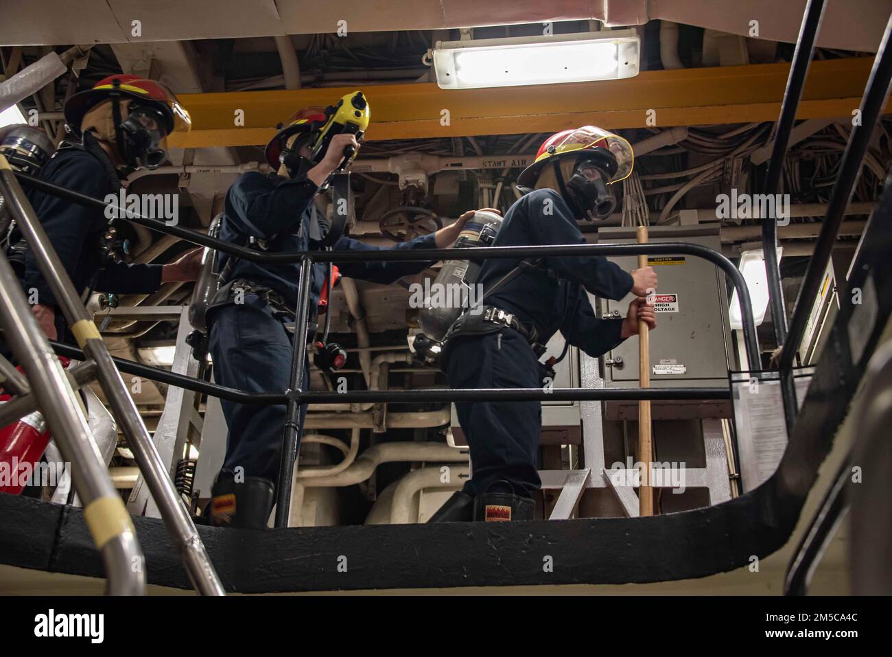 220228-N-XB010-1001 EAST CHINA SEA (Feb. 28, 2022) Sailors assigned to USS New Orleans (LPD 18) overhaul a space during a damage control training team evolution. New Orleans, part of the America Amphibious Ready Group, along with the 31st Marine Expeditionary Unit, is operating in the U.S. 7th Fleet area of responsibility to enhance interoperability with allies and partners and serve as a ready response force to defend peace and stability in the Indo-Pacific region. Stock Photo