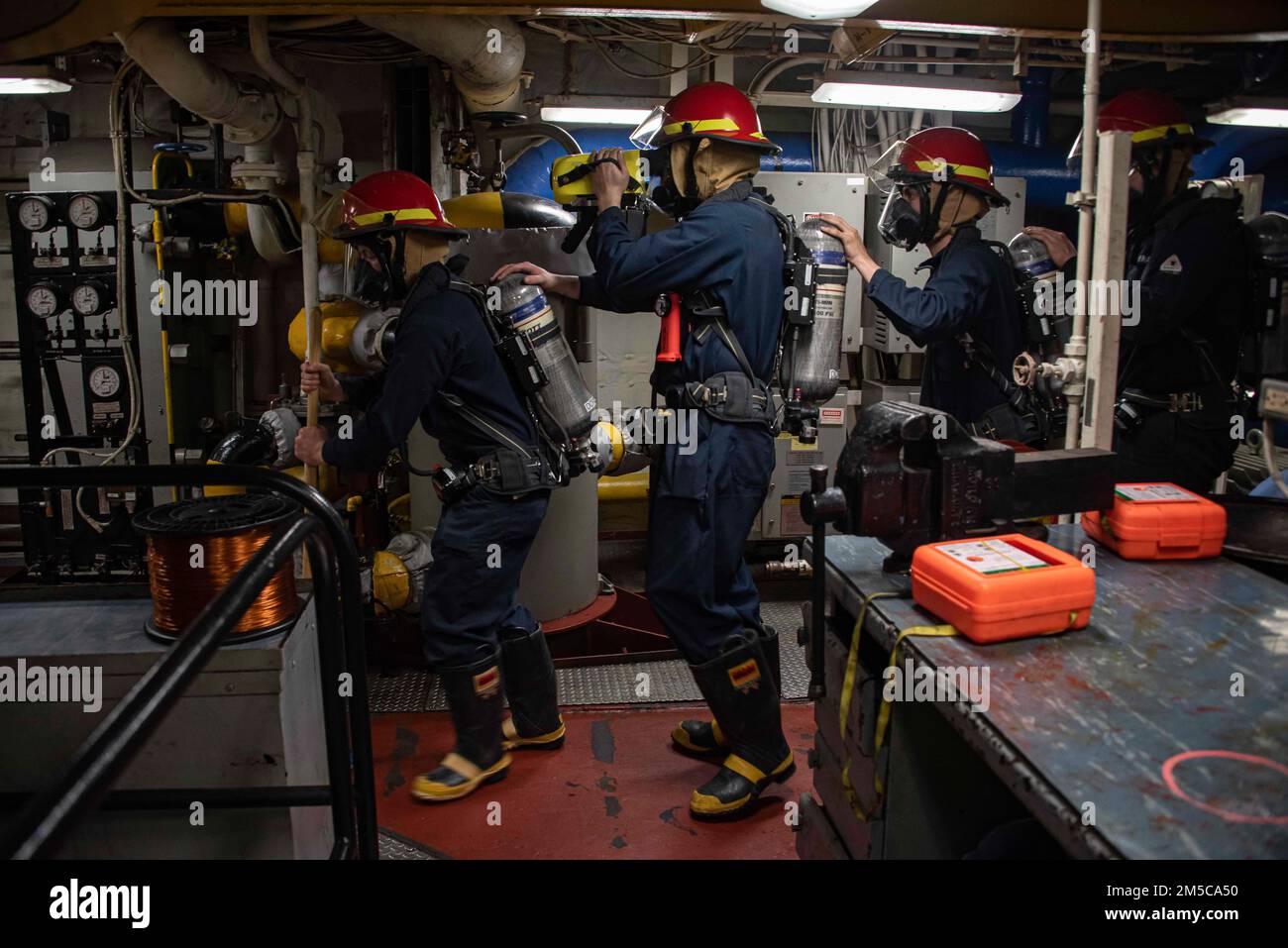 220228-N-XB010-1002 EAST CHINA SEA (Feb. 28, 2022) Sailors assigned to USS New Orleans (LPD 18) overhaul a space during a damage control training team evolution. New Orleans, part of the America Amphibious Ready Group, along with the 31st Marine Expeditionary Unit, is operating in the U.S. 7th Fleet area of responsibility to enhance interoperability with allies and partners and serve as a ready response force to defend peace and stability in the Indo-Pacific region. Stock Photo
