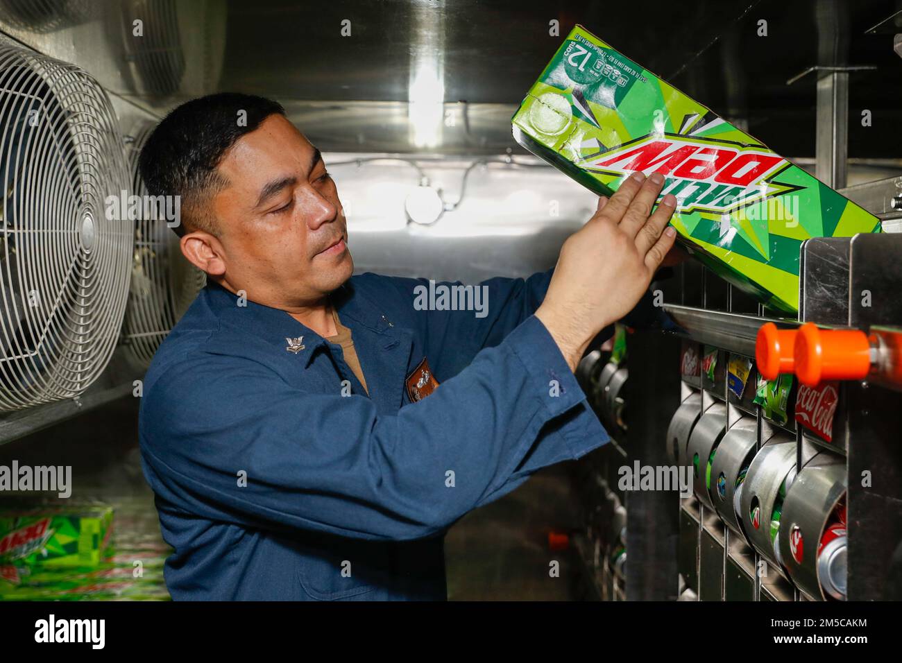 PHILIPPINE SEA (March 1, 2022) Retail Specialist 2nd Class Mark Lester Tria, from San Diego, restocks the vending-in-a-box (VIB) aboard the Nimitz-class aircraft carrier USS Abraham Lincoln (CVN 72). Abraham Lincoln Strike Group is on a scheduled deployment in the U.S. 7th Fleet area of operations to enhance interoperability through alliances and partnerships while serving as a ready-response force in support of a free and open Indo-Pacific region. Stock Photo