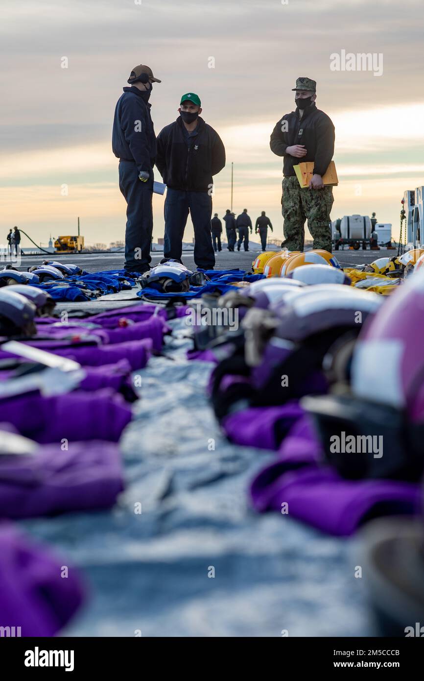 220301-N-HA192-1271 NORFOLK, VA. (March 1, 2022) - Sailors assigned to the  amphibious assault ship USS Bataan (LHD 5), prepare float coats and  cranials for inspection, March 1, 2022. Bataan is underway in