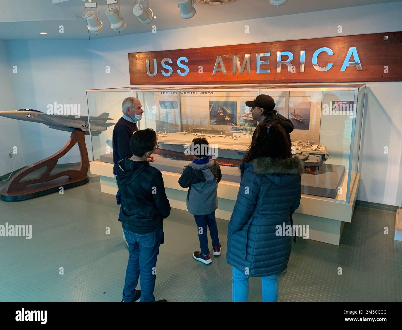 Longtime museum volunteer Russ Martin provides some meaningful historical interpretation to the builder’s model of USS America (CV-66) to some visitors at the Hampton Roads Naval Museum. The museum, located on the second floor of the Nauticus campus in Downtown Norfolk, Virginia, is home to a robust volunteer corps. Stock Photo